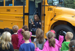 Marie Noeth talks to students in front of school bus