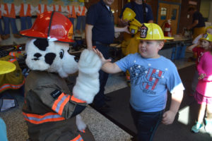 Student gives high five to Sparky the fire dog