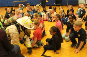 Fireman crawling on floor during fire safety presentation