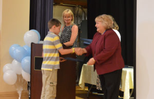 Student receives certificate from Principal Yeomans