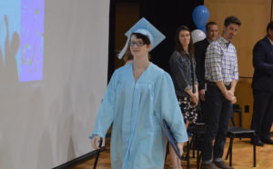 Student walking with diploma