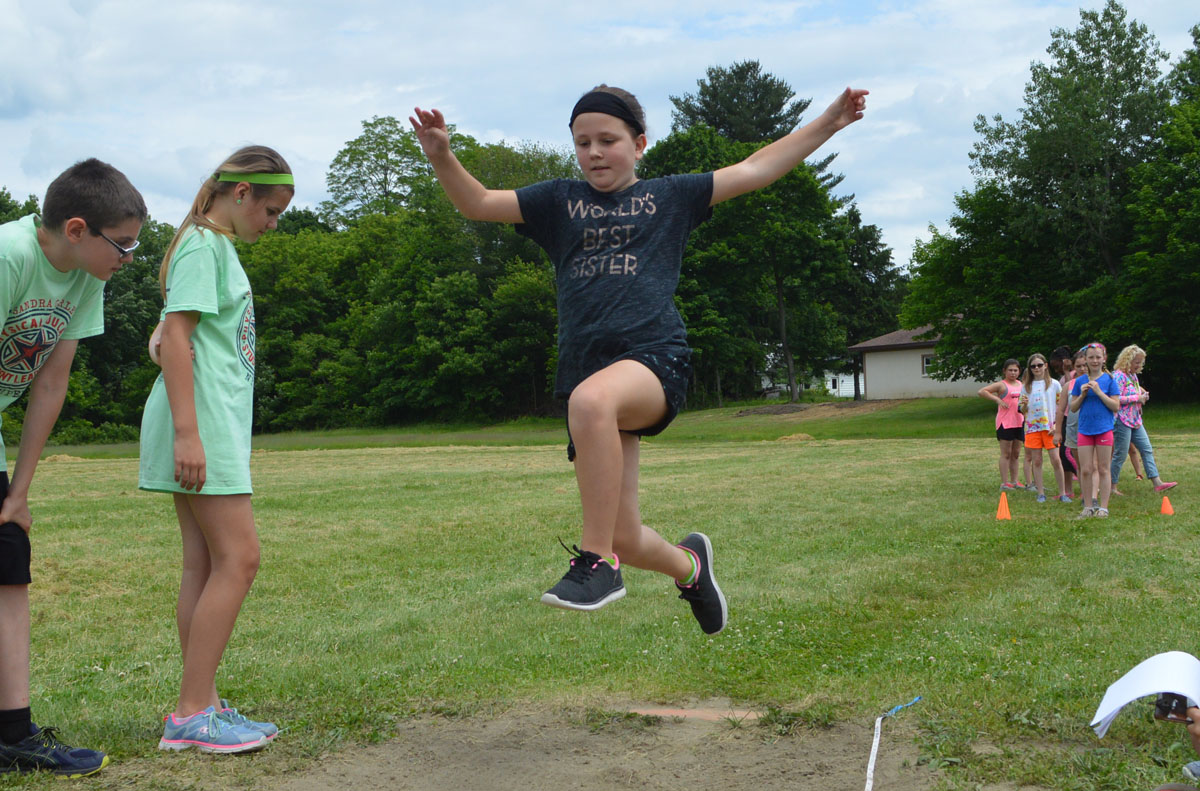 Student competes in long jump event at Field Day