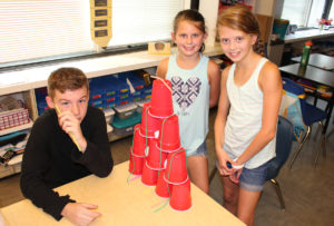 Students build a pyramid of plastic cups