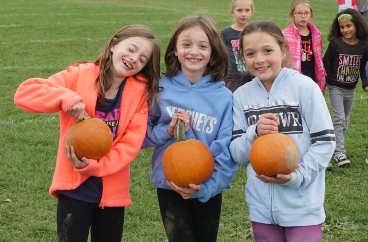 Students holding pumpkins