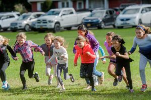 Students running in Green Meadow Apple Race