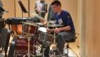 Student playing drums on stage