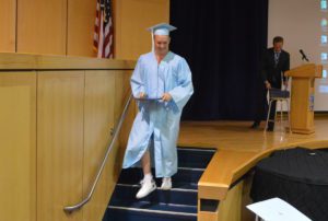 Graduate walks off stage with his diploma