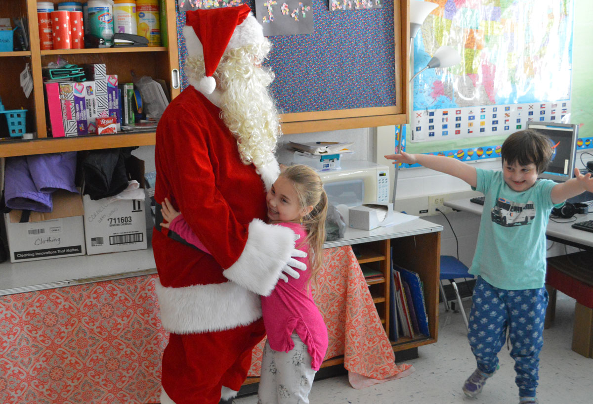 Student hugs Santa Claus at Green Meadow