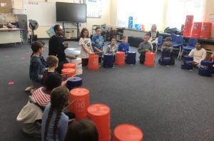 Students drumming on buckets