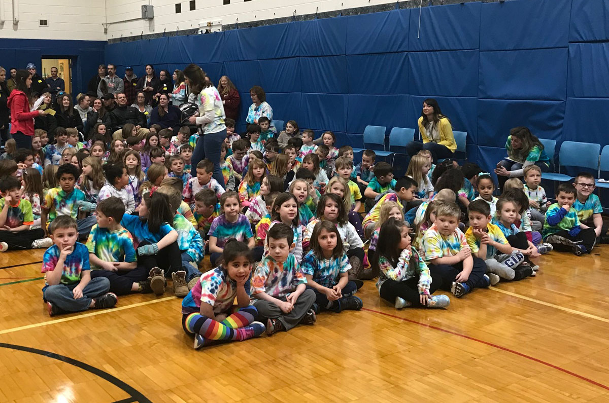 Students wearing tie dye shirts at Character Assembly