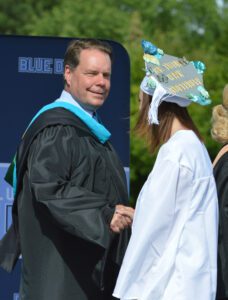 Superintendent Jeff Simons shakes hands with a Columbia graduate
