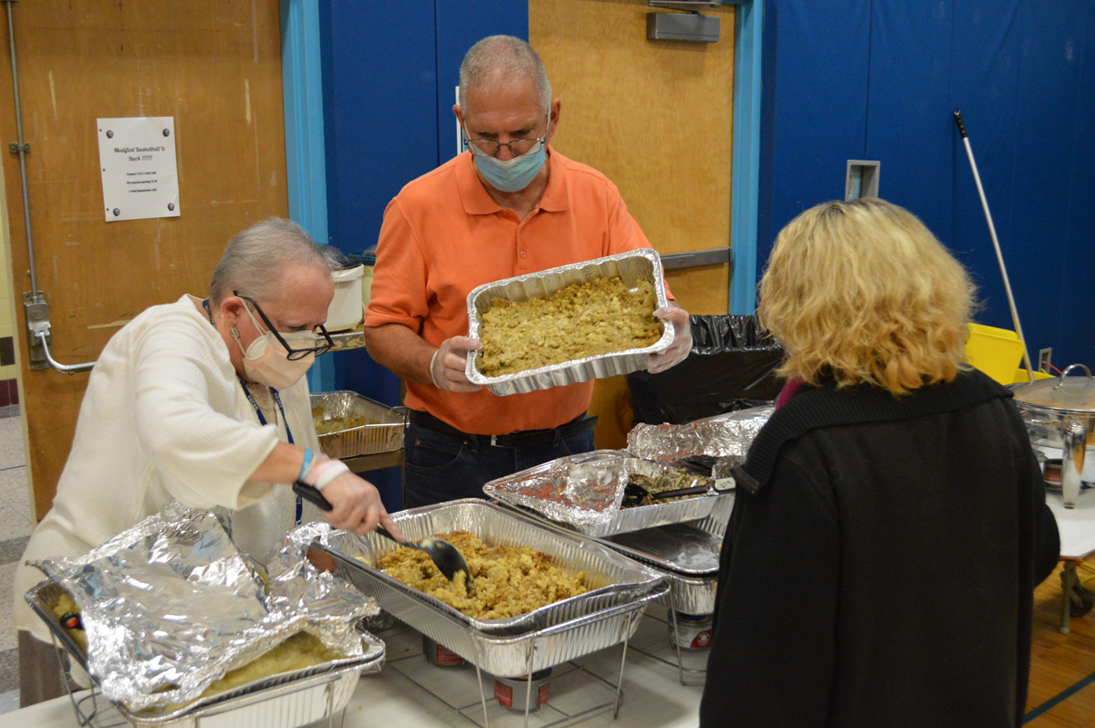 Linda Pavlick and Steve Taylor serve food at Goff Middle School's Thanksgiving Feast.