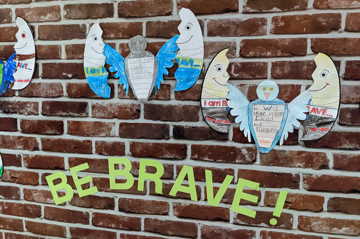 Student drawings on a brick wall