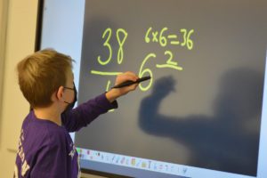 A student solves a math problem on a new ViewSonic board in his classroom at Red Mill