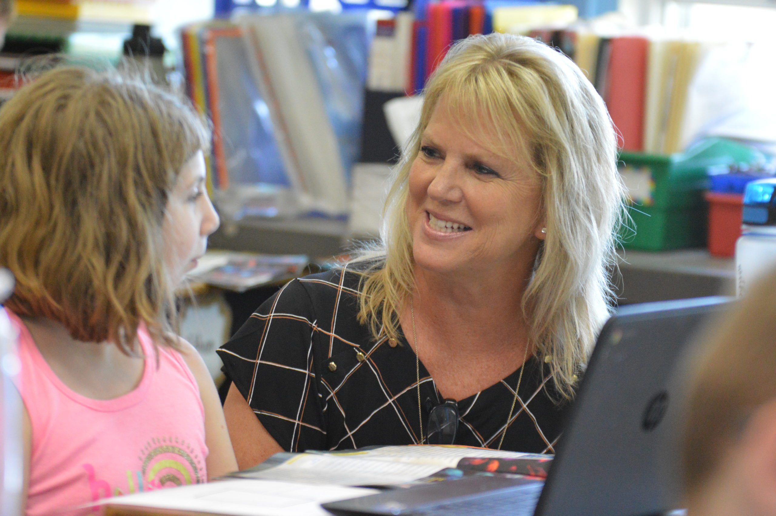 Mrs. Hart working with a student at her desk