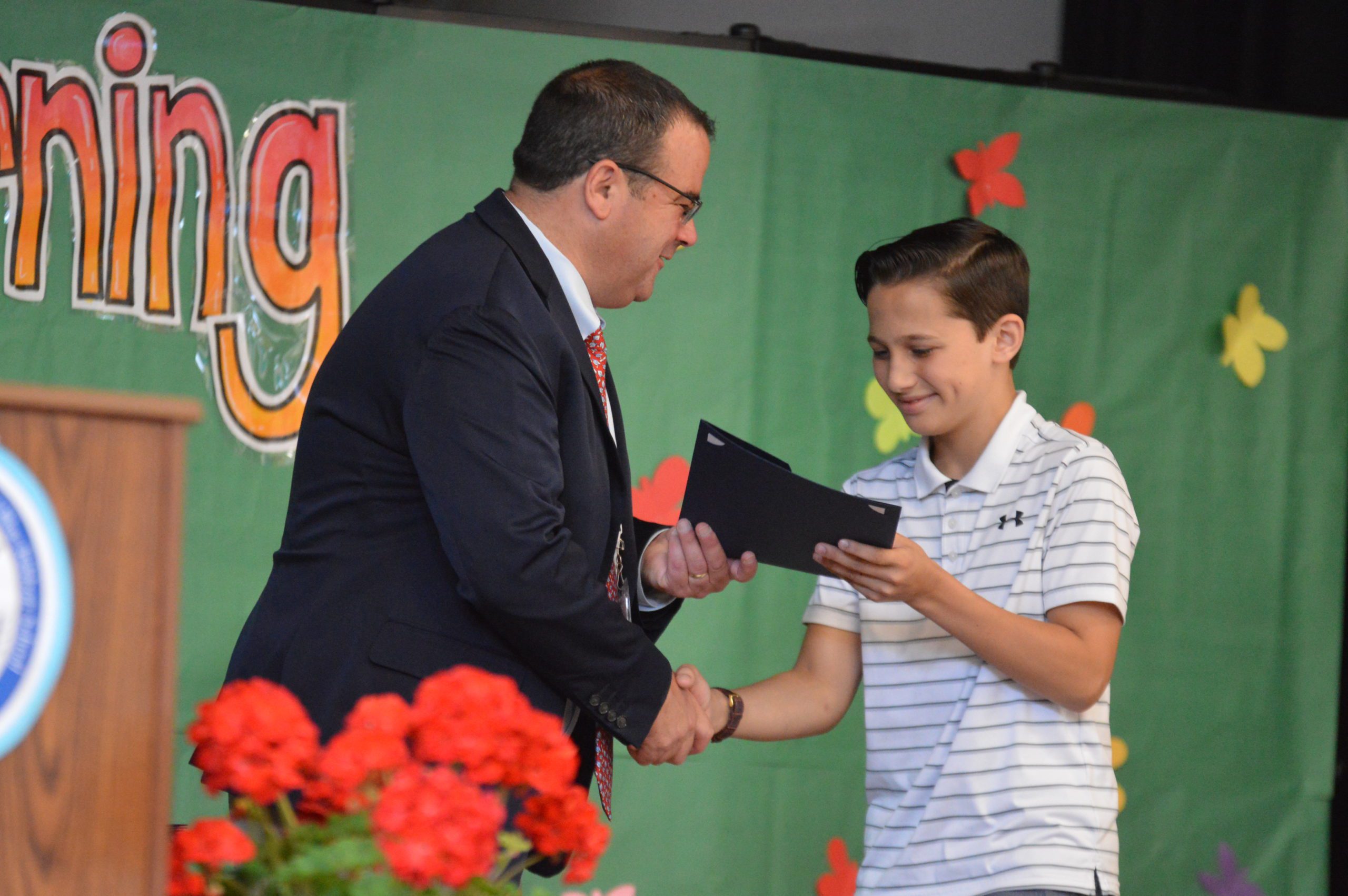 A Green Meadow student receives their certificate.