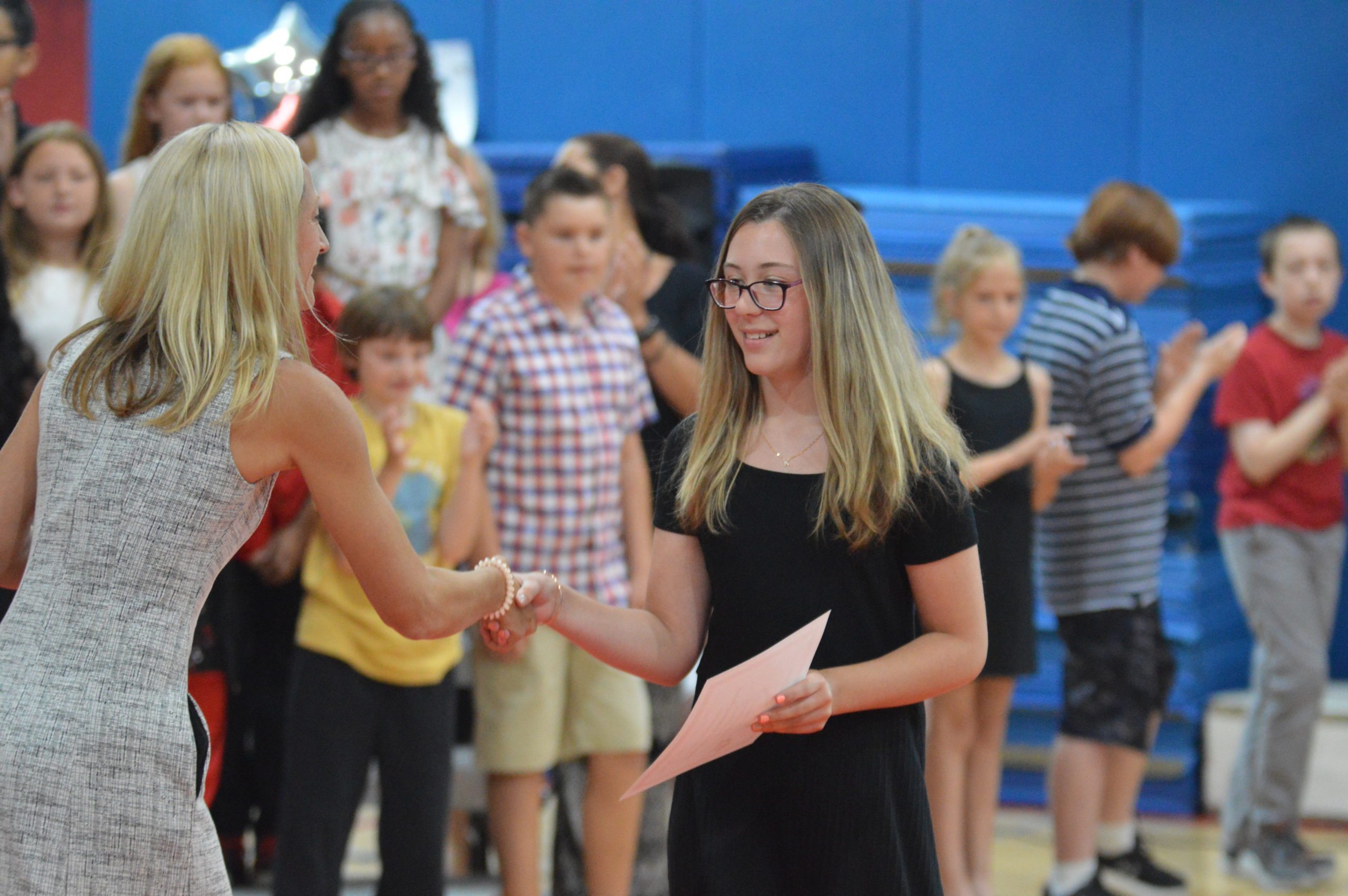 A Red Mill student receives certificate at the Moving Up Ceremony
