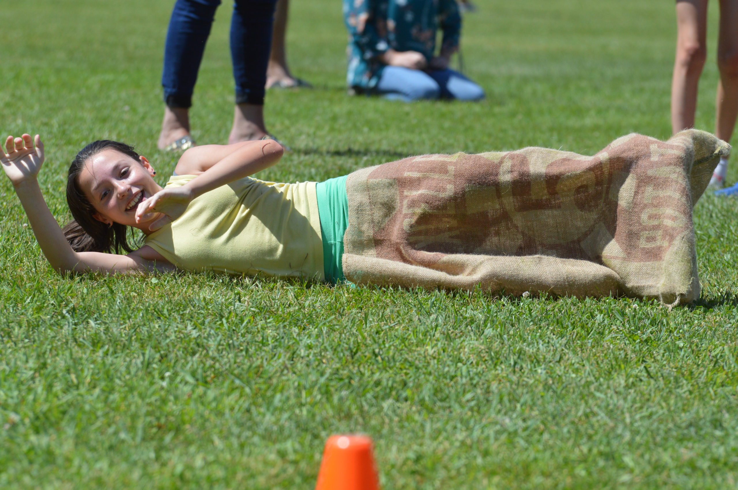 A student rolls on the ground at DPS Field Day