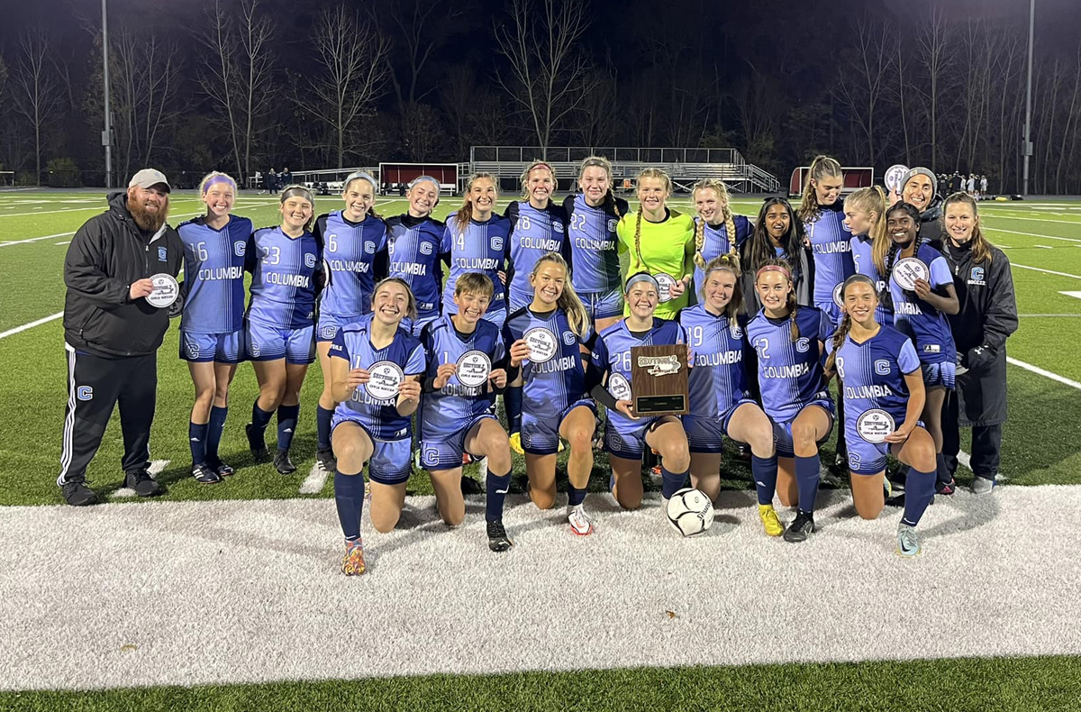 Columbia girls soccer team holding sectional championship patches 