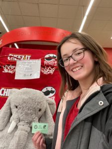 A student with Veda the stuffed elephant at Hannaford