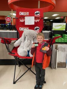 A student with Veda the stuffed elephant at Hannaford