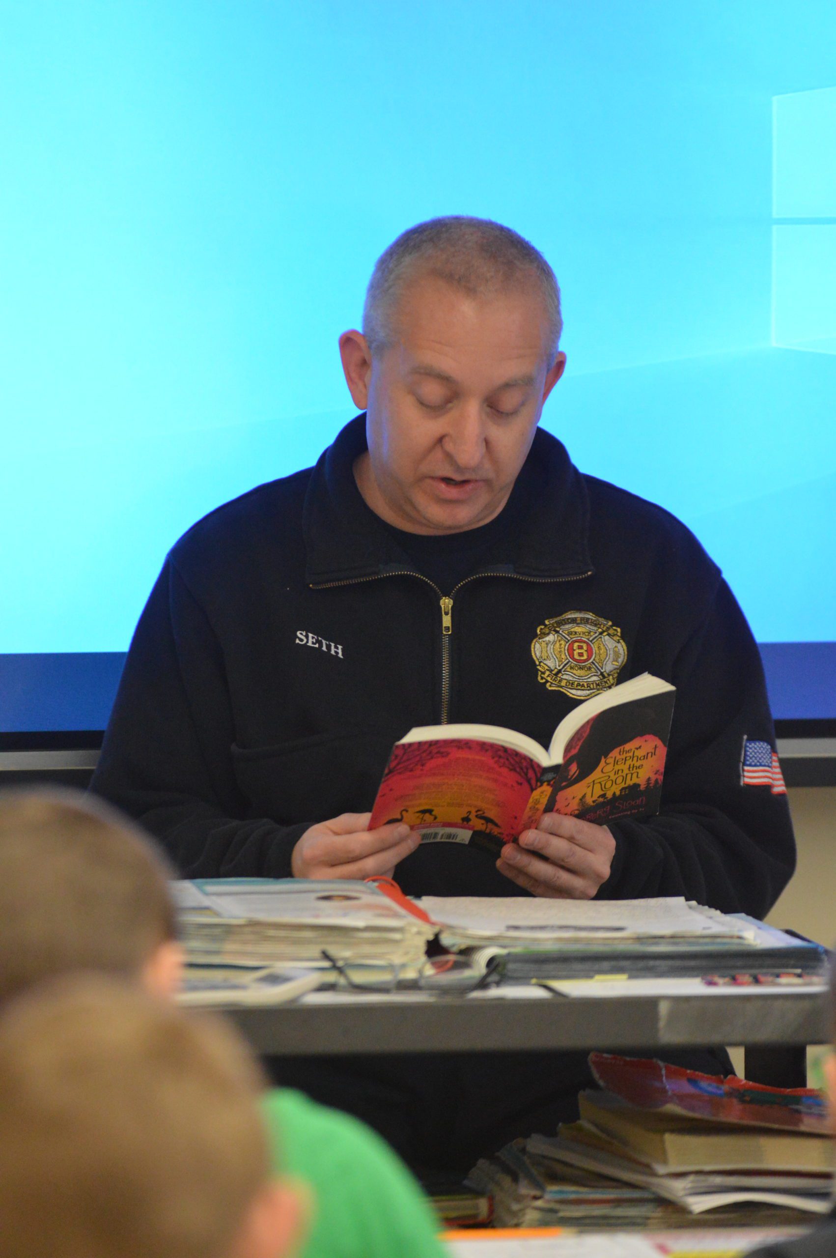Clinton Heights Fire Chief Seth Tracy reading to students at Red Mill