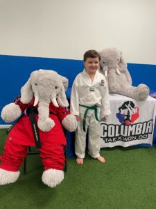 A student with Veda the stuffed elephant at Columbia Tae Kwon Do