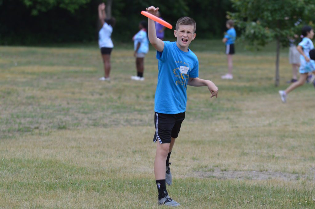 Student throws a frisbee at 5th Grade Mixer