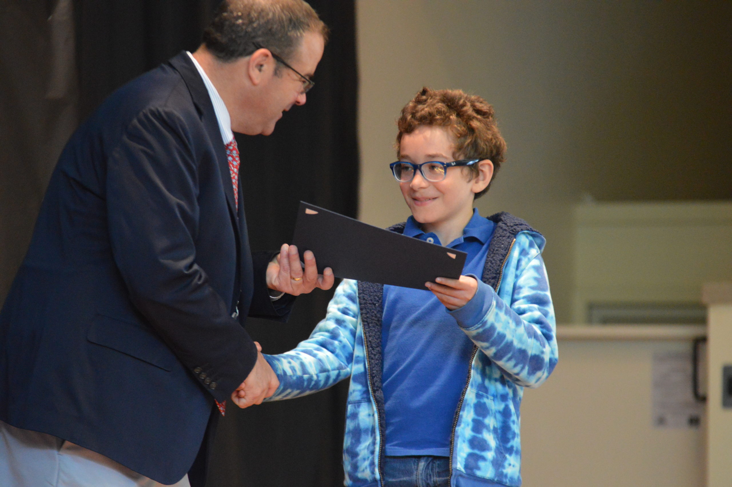 Student receives certificate at Green Meadow Moving Up Ceremony