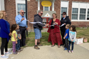 Head Custodian Frank Cramer and Library Media Specialist Peg O'Connor cut the ribbon at the new Little Free Library at DPS.