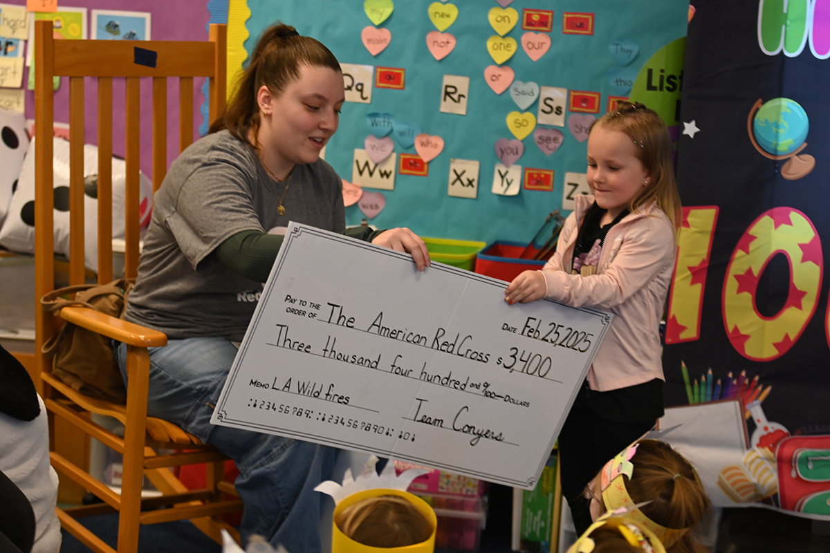Student presents check to Red Cross
