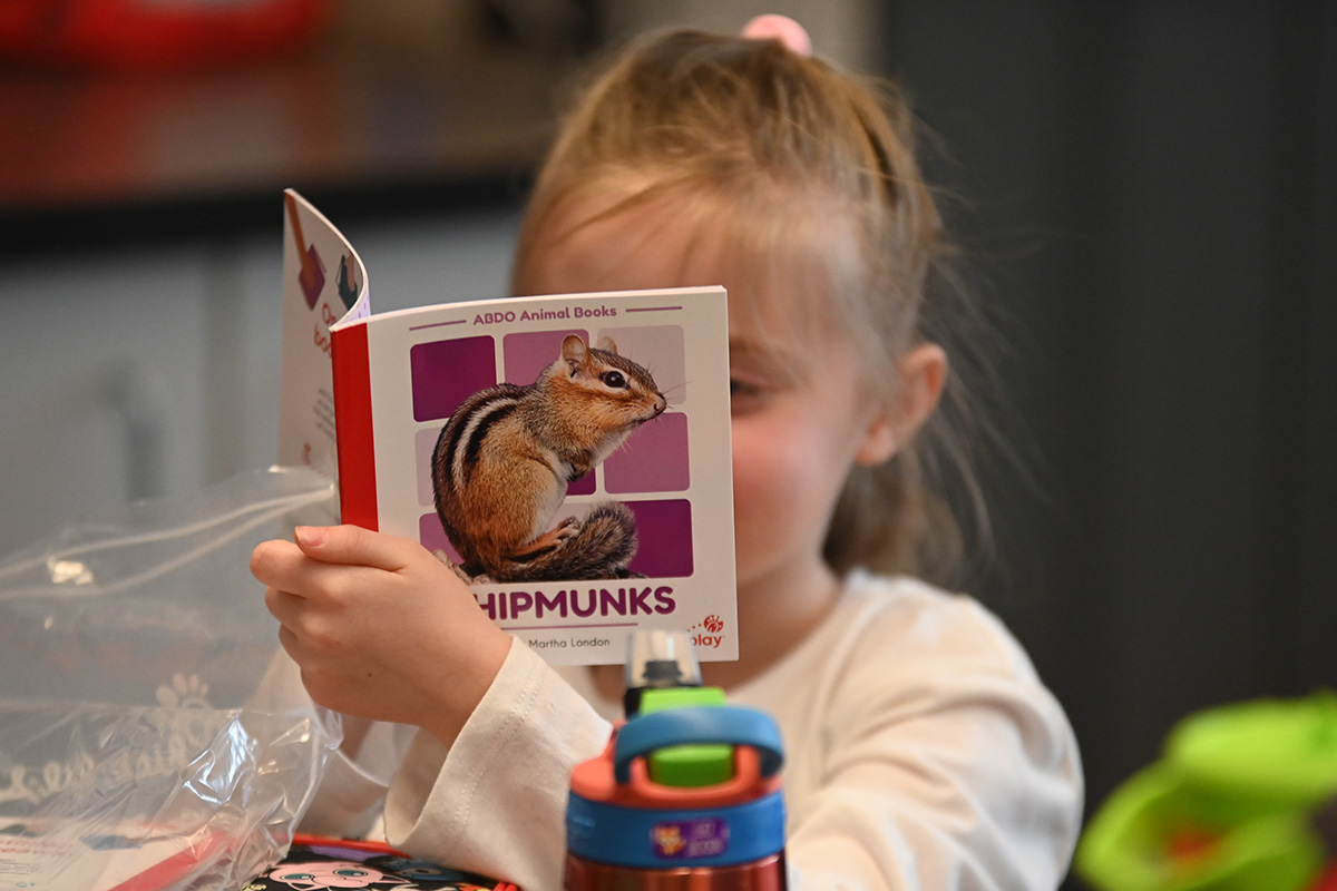 A Green Meadow student reads a book about chipmunks