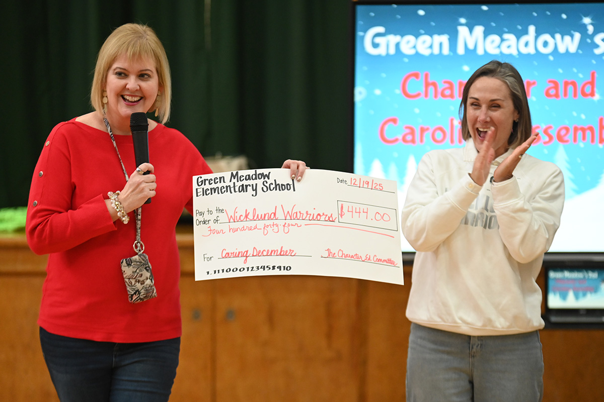 Sue Rys presents a donation to Wicklund Warriors founder and president Deanna Wicklund in support of families with blood cancer