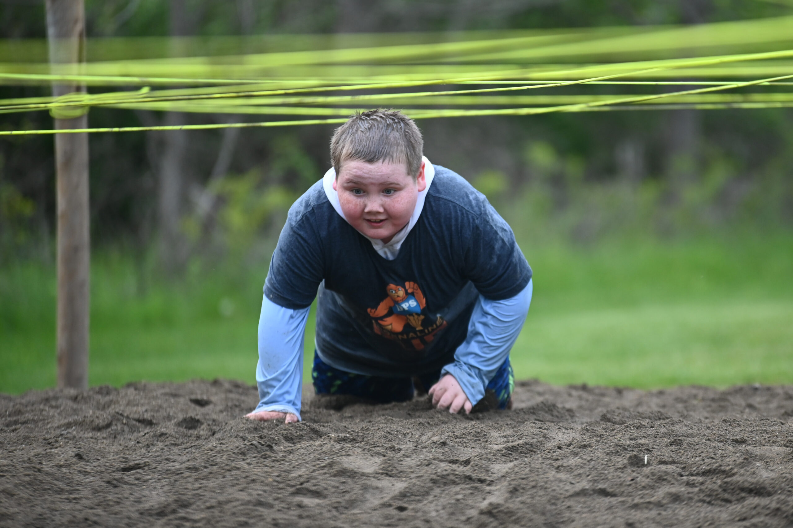 A student crawls under rope during the 2026 DPS Adrenaline Run