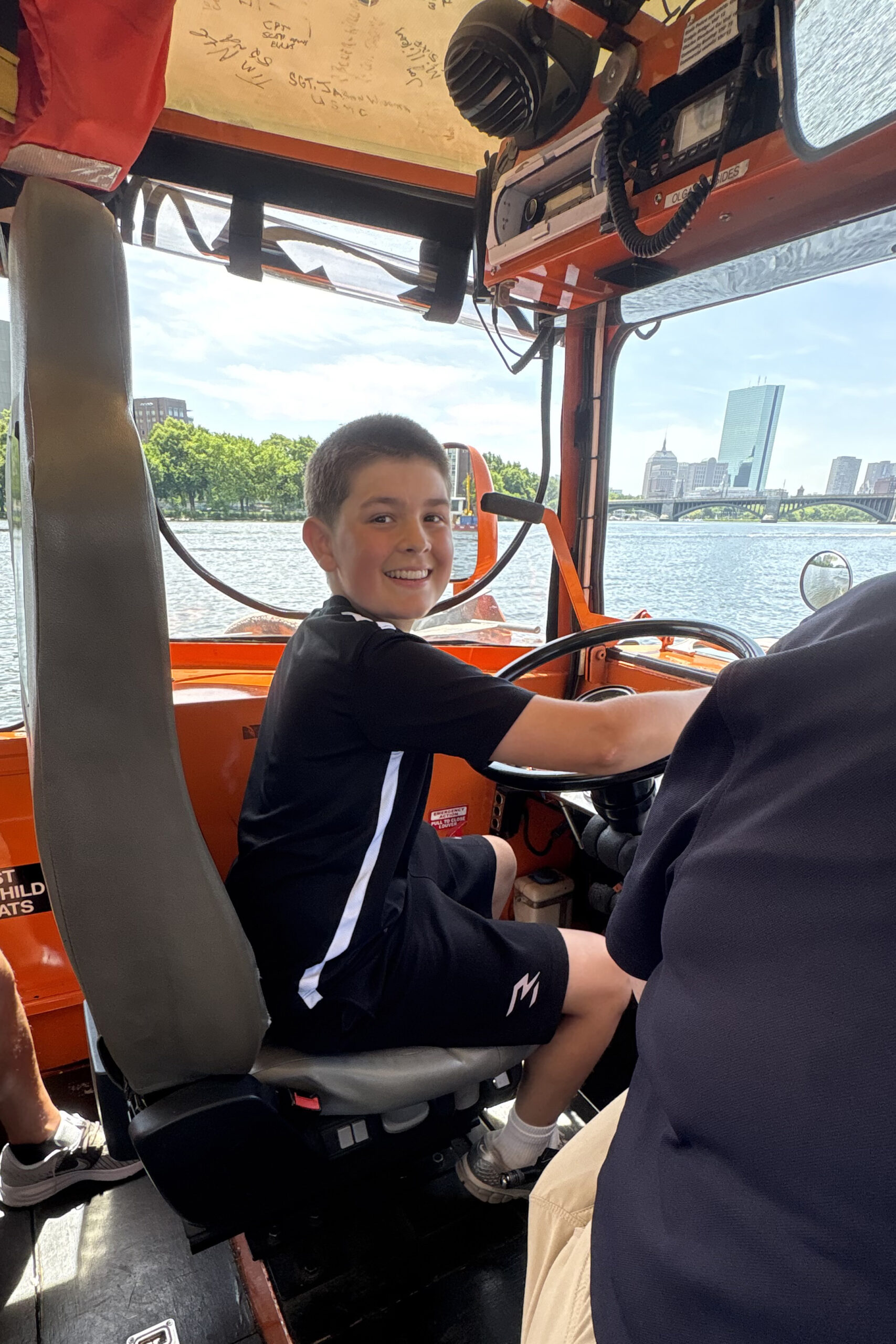 Student driving duck boat on class trip to Boston