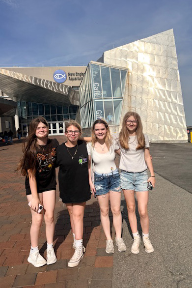 Four students in front of Boston Aquarium