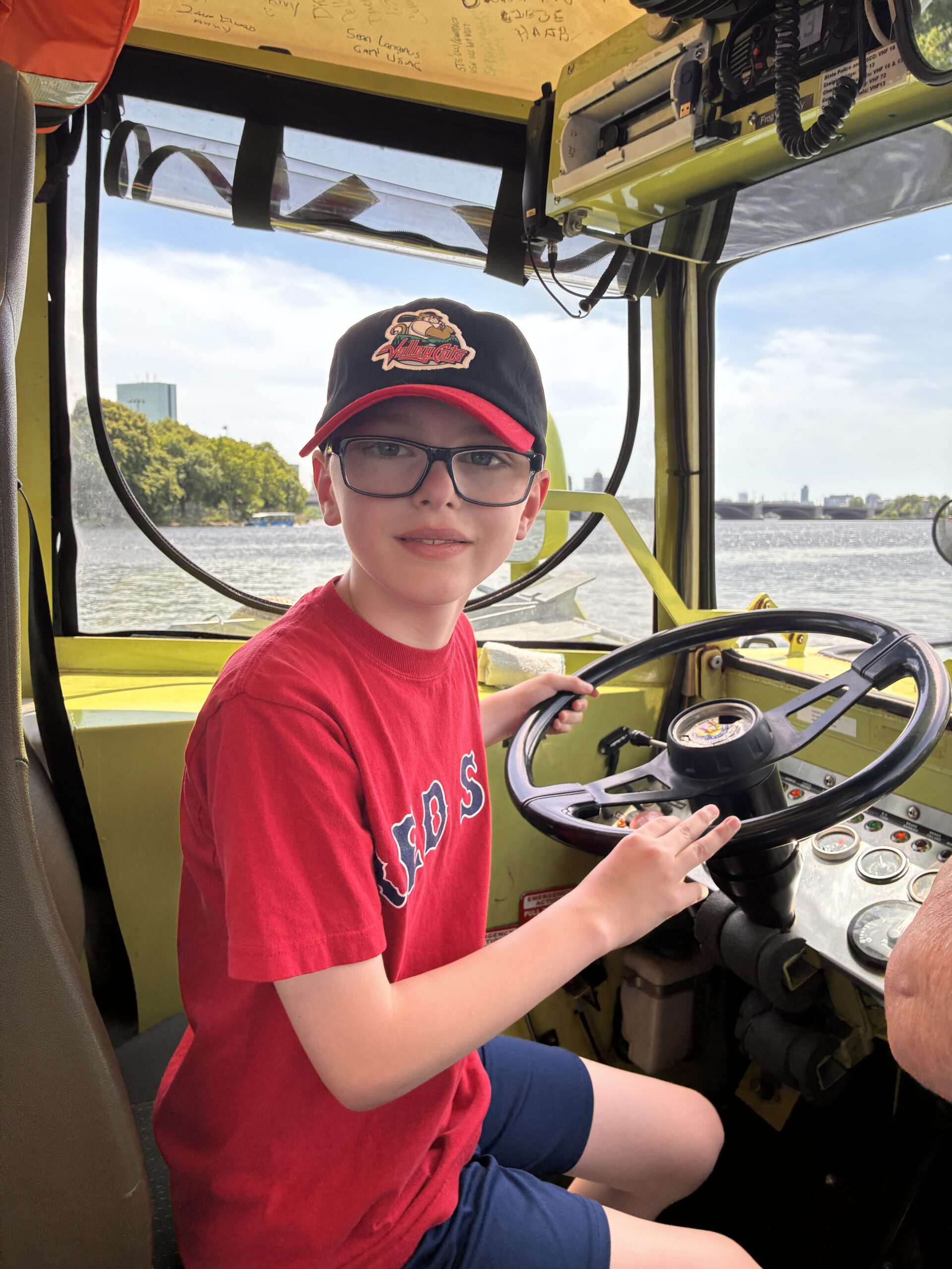 Student driving duck boat on class trip to Boston