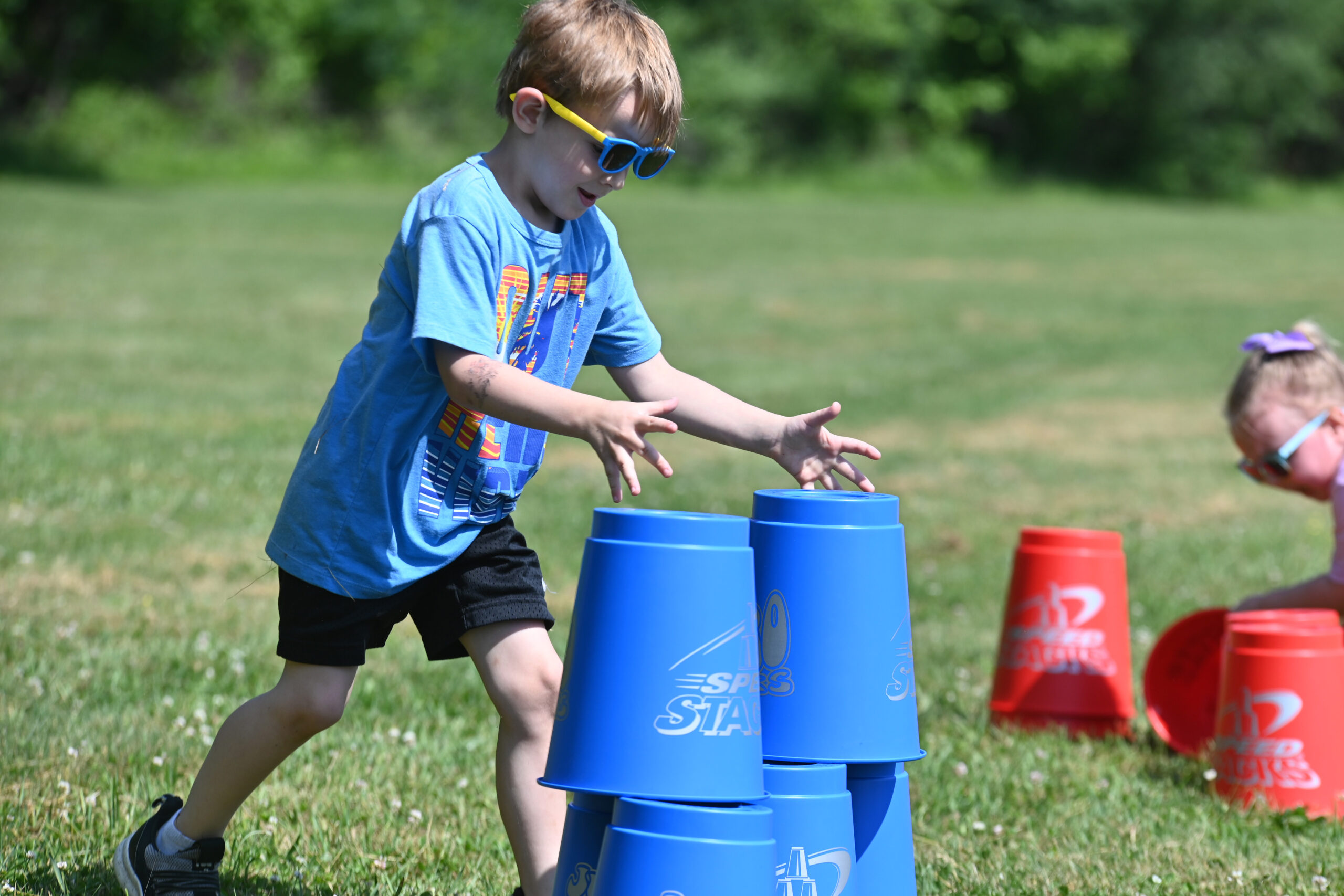 A student stacks buckets during a race at DPS Field Day