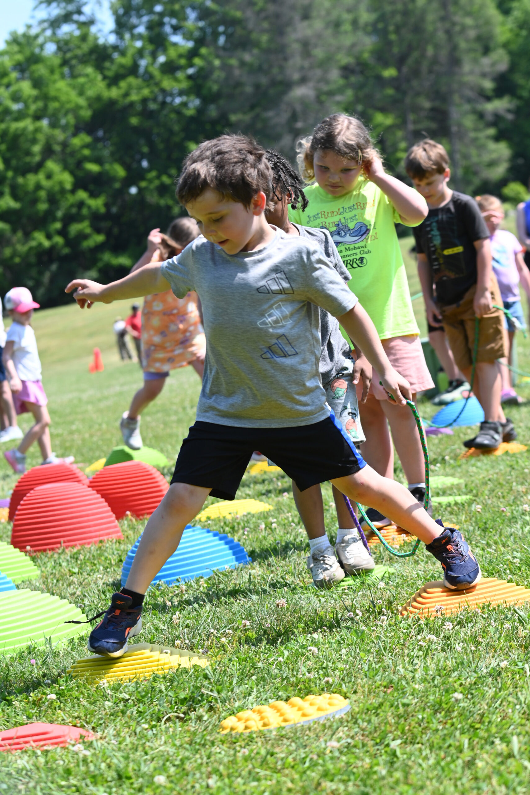 A student moves across stepping stones at DPS Field Day