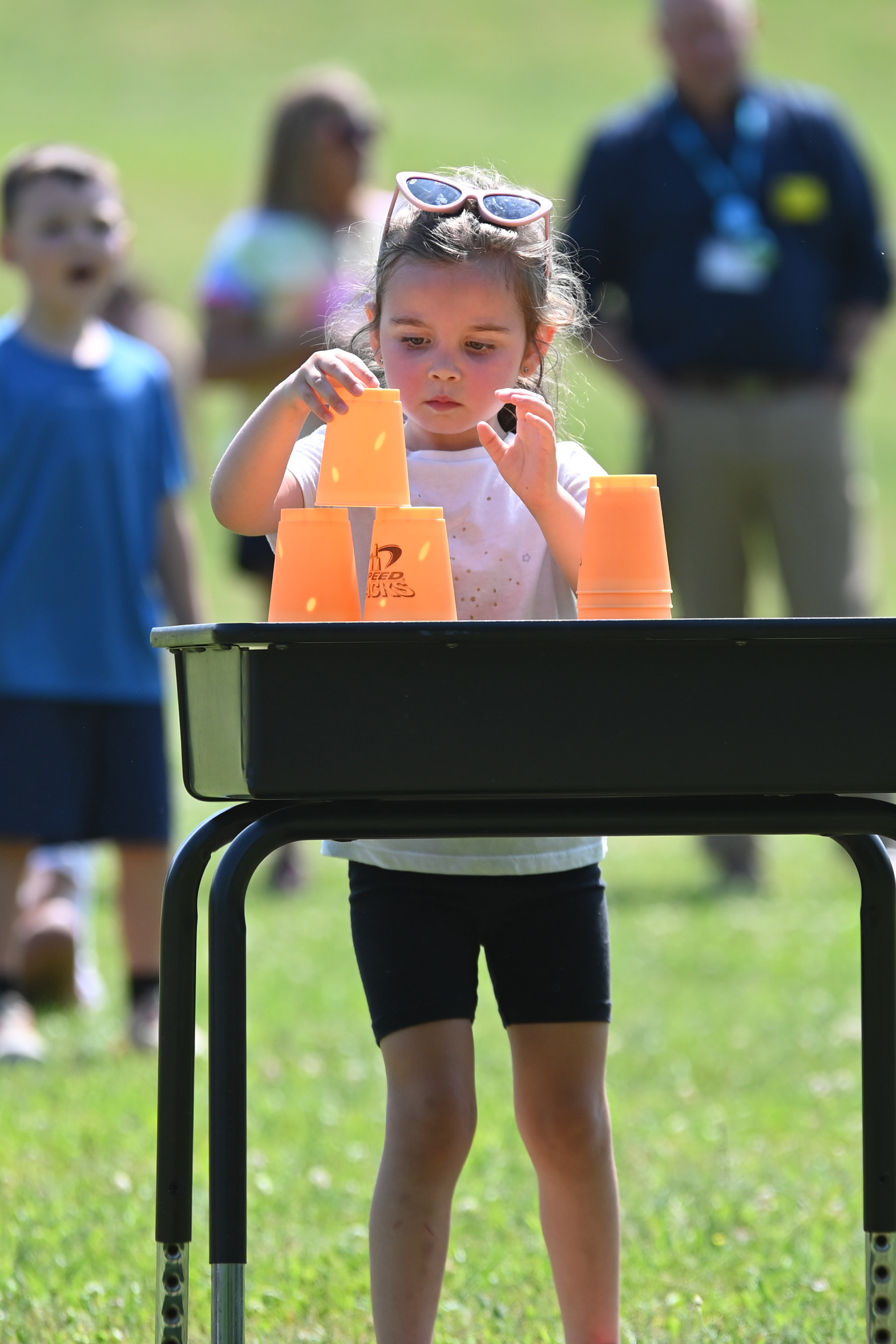 A student stacks cups during a race at DPS Field Day