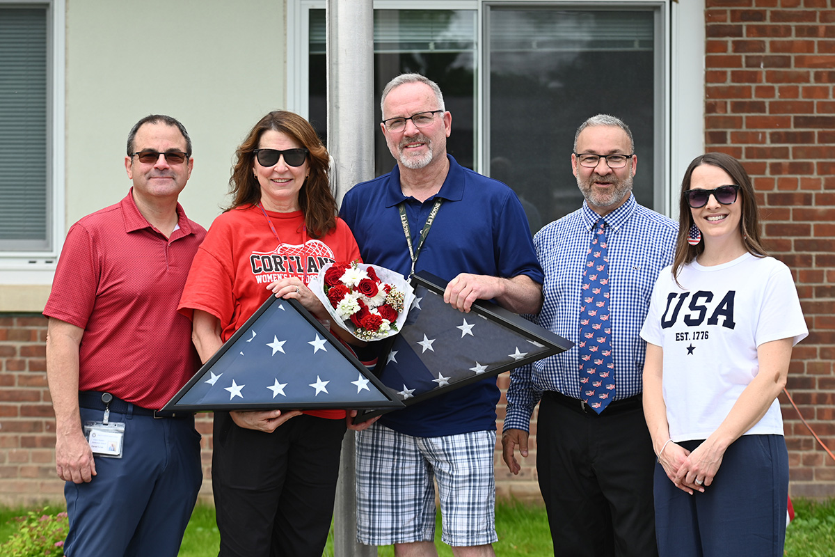Retiring teachers Diane Cohen and Bruce Otto are presented with folded American flags on Flag Day