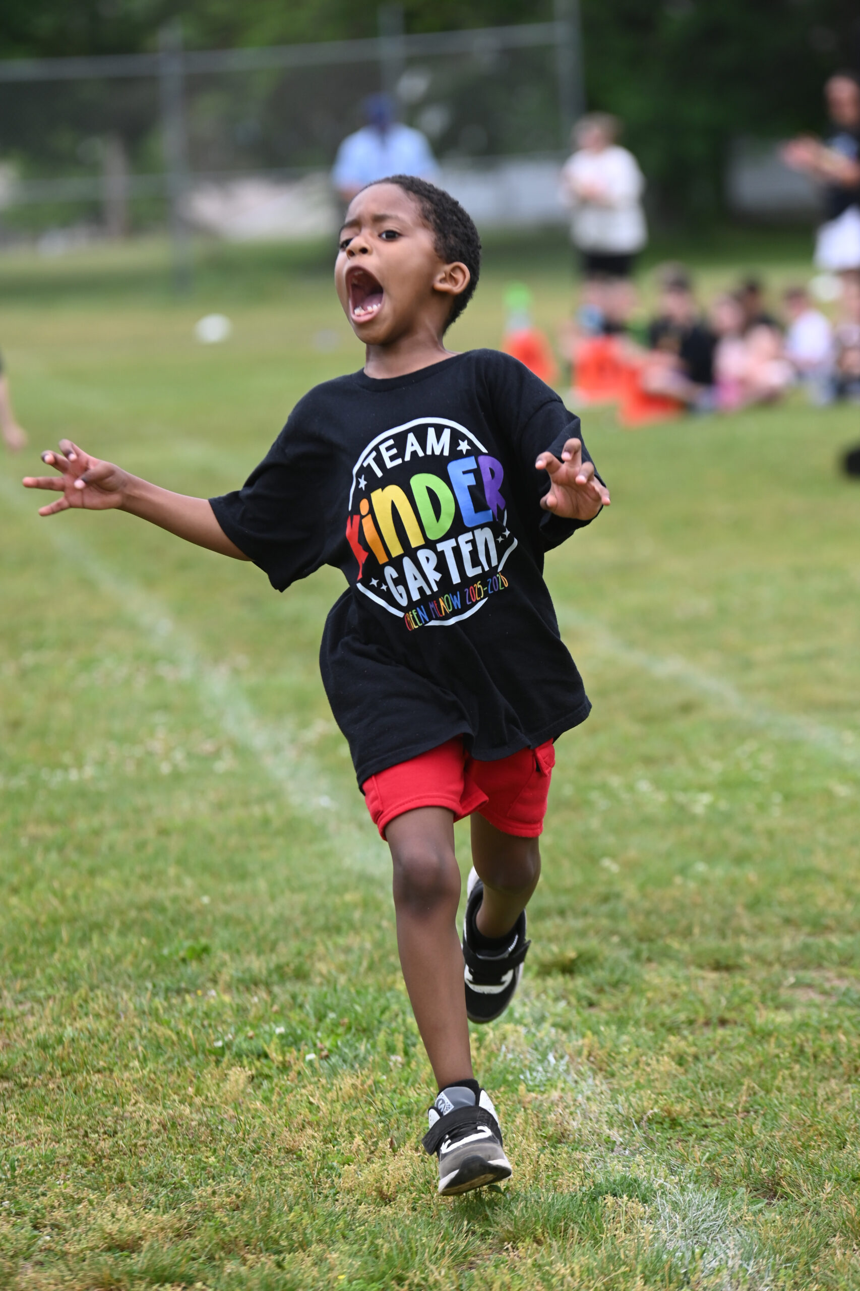 A student running at Green Meadow Kindergarten Field Day