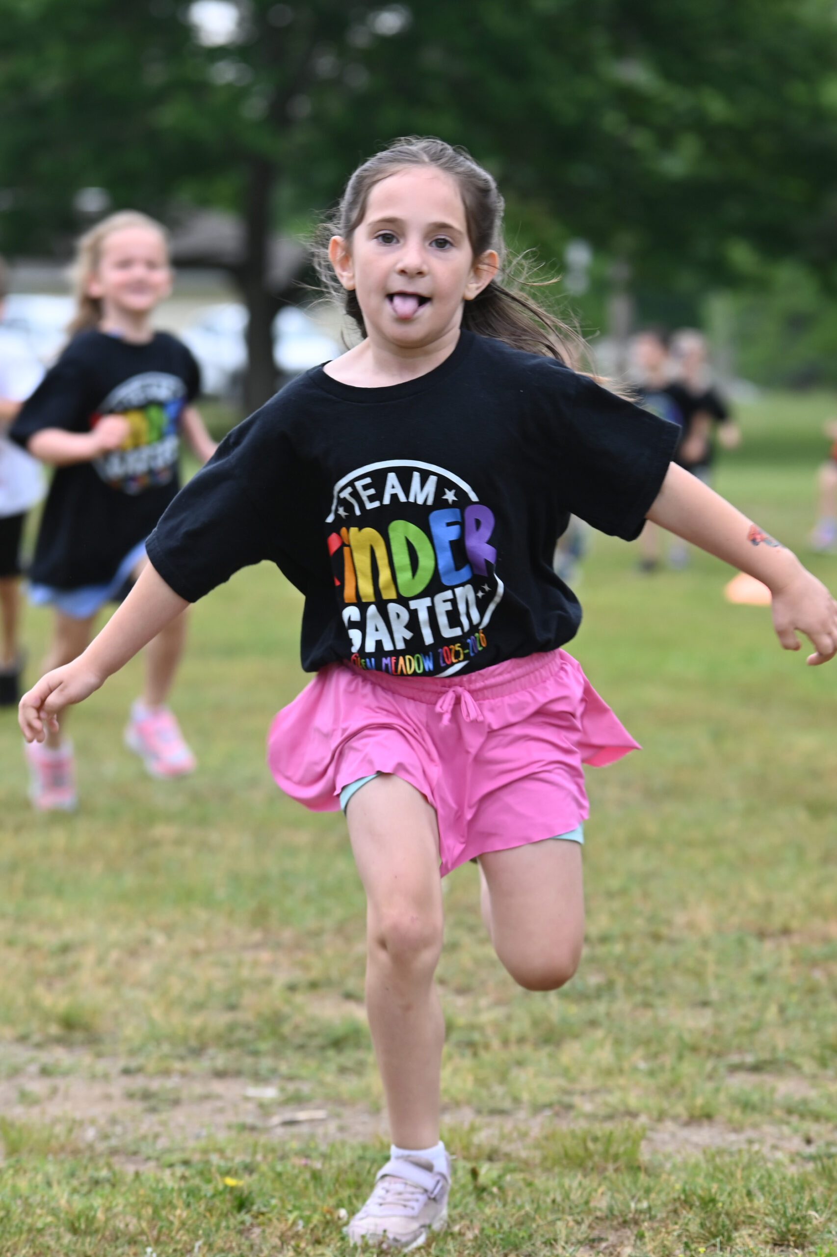 A student running at Green Meadow Kindergarten Field Day