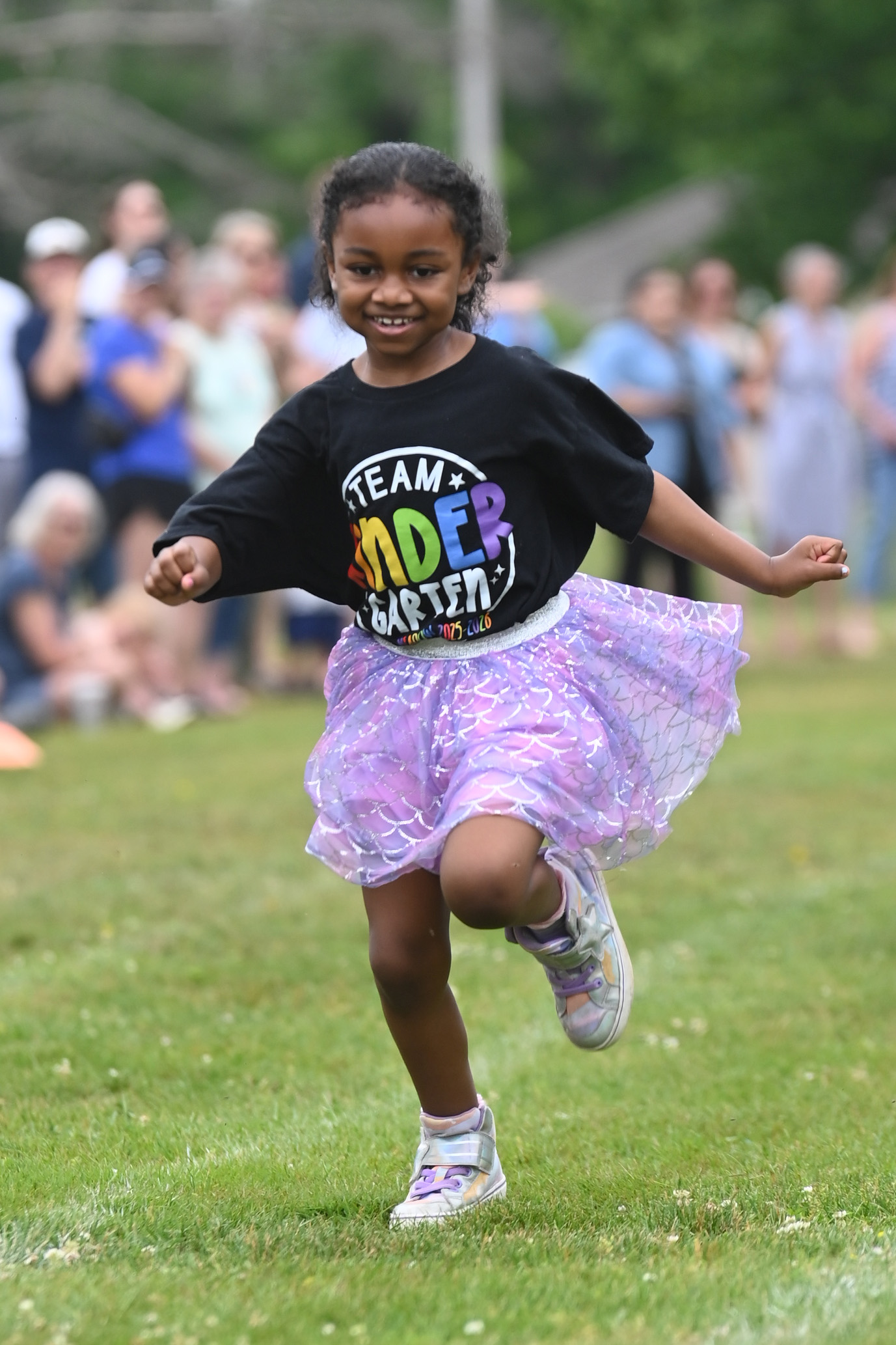 A student running in a tutu at Green Meadow Kindergarten Field Day