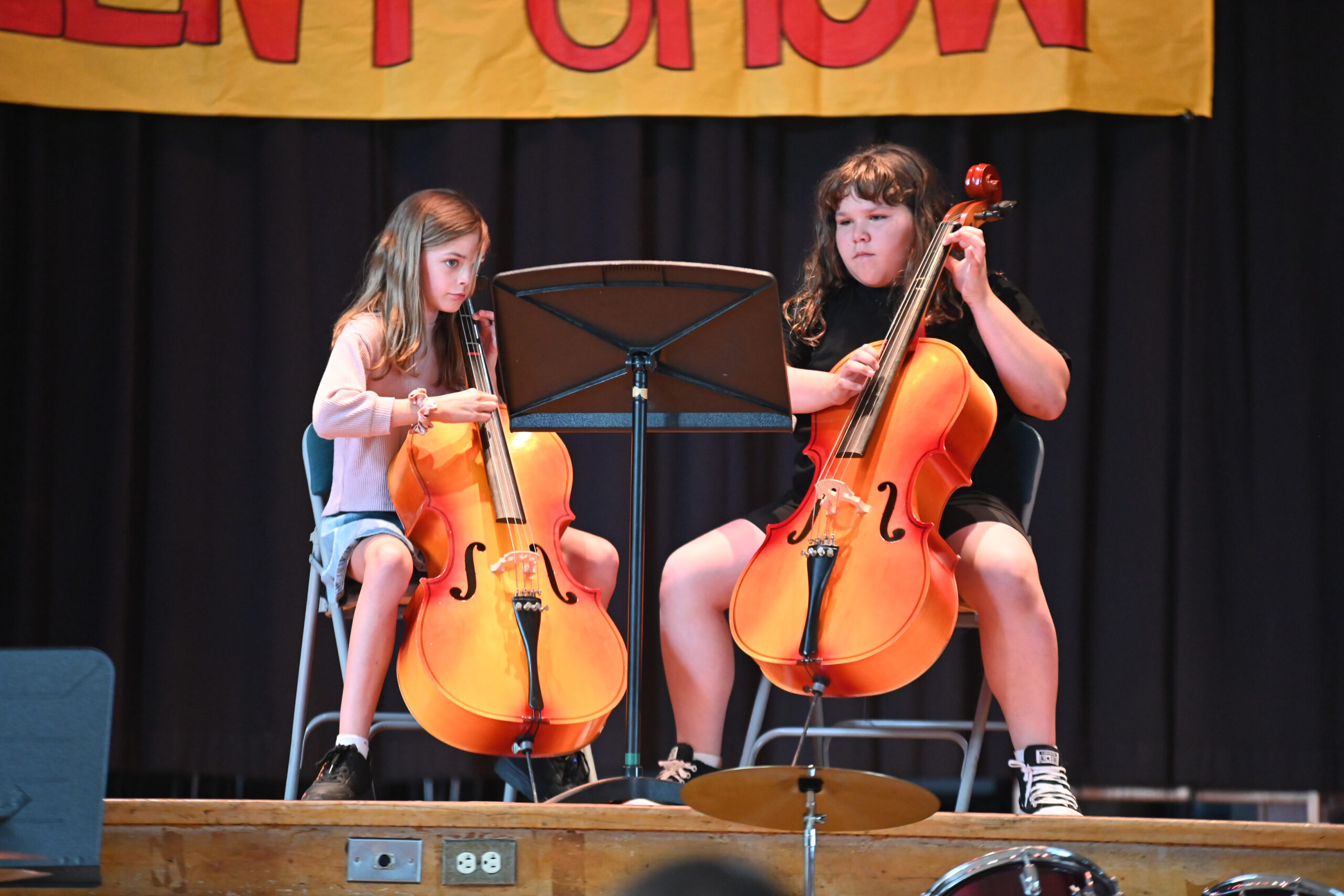 Two students playing cello on stage at the Green Meadow Talent Show